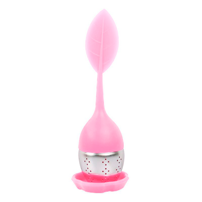 Zaparzacz do herbaty w kształcie jajka z uchwytem listkiem w kolorze jasnoróżowym na podstawce.