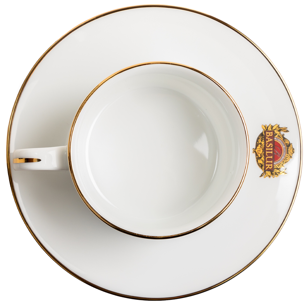 Widok z góry na filiżankę porcelanową Basilur ze spodkiem i złotym rantem.