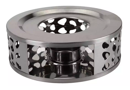 Metalowy podgrzewacz do dzbanka z miejscem na tealight prezentowany z boku w dekoracyjnym wzorze.