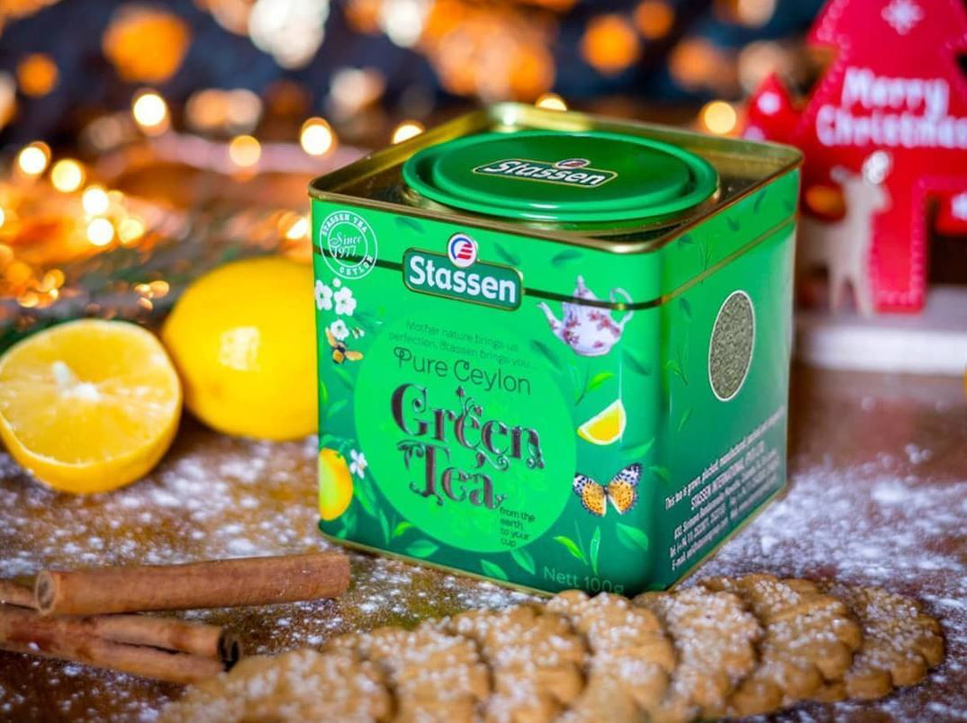 Herbata Stassen Green Tea z cytryną i cynamonem w tle, świąteczny klimat.