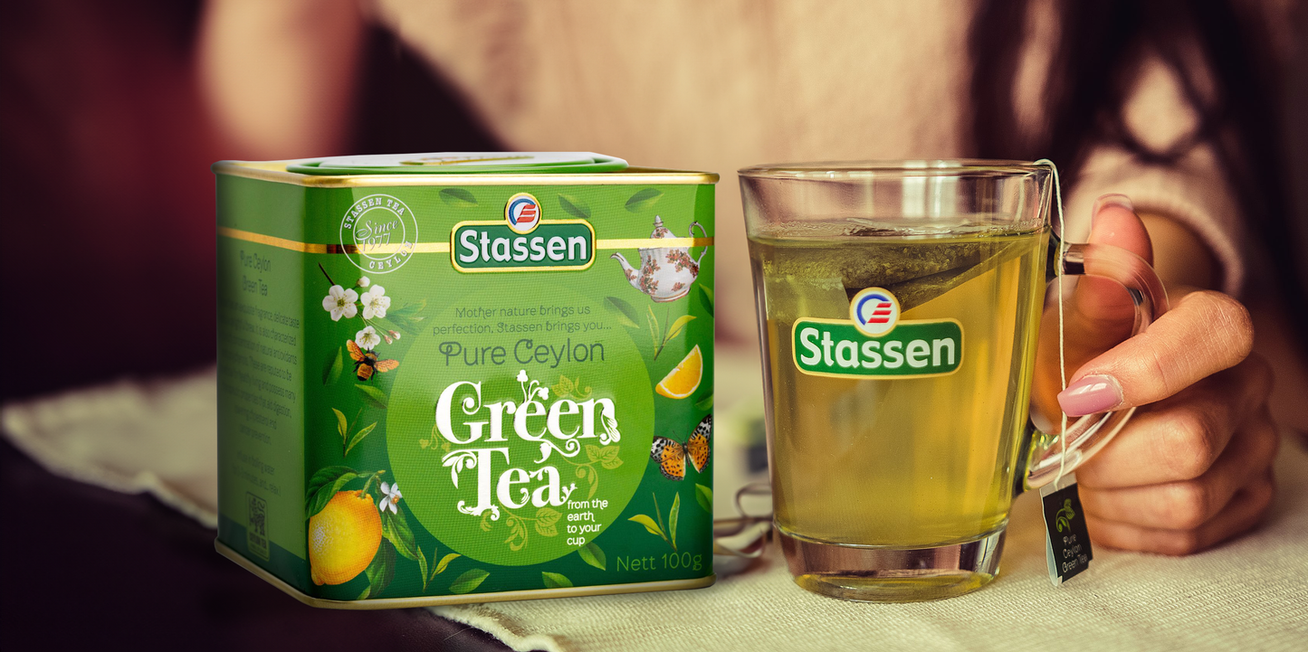 Puszka Stassen Green Tea obok filiżanki z naparem, świeża herbata cejlońska.