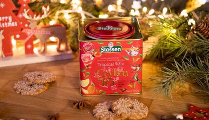 Puszka Stassen Tropical Mix na drewnianym stole w otoczeniu świątecznych ciasteczek.