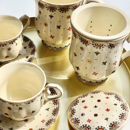 Zestaw porcelanowych filiżanek i kubka Casablanca z zaparzaczem i pokrywką na złotej tacy.