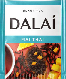 Saszetka herbaty Dalai Mai Thai z czarną herbatą i kawałkami owoców na tle liści herbaty