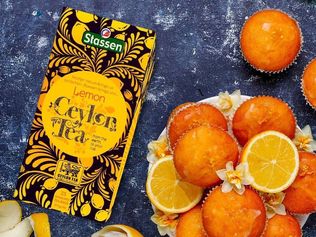 Stylizowane zdjęcie herbaty Stassen Lemon Tea z muffinkami cytrynowymi.