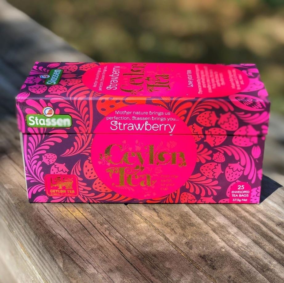 Pudełko Stassen Strawberry Tea na drewnianym tle – herbata czarna z truskawką.