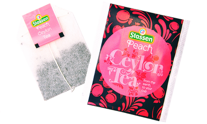Torebka herbaty i saszetka Stassen Peach Tea ułożone pod kątem – owocowa herbata cejlońska.