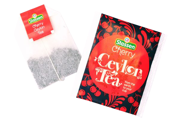 Zbliżenie na kopertę i torebkę herbaty czarnej Stassen Cherry Tea – cejlońska herbata wiśniowa.