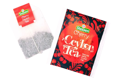 Zbliżenie na kopertę i torebkę herbaty czarnej Stassen Cherry Tea – cejlońska herbata wiśniowa.