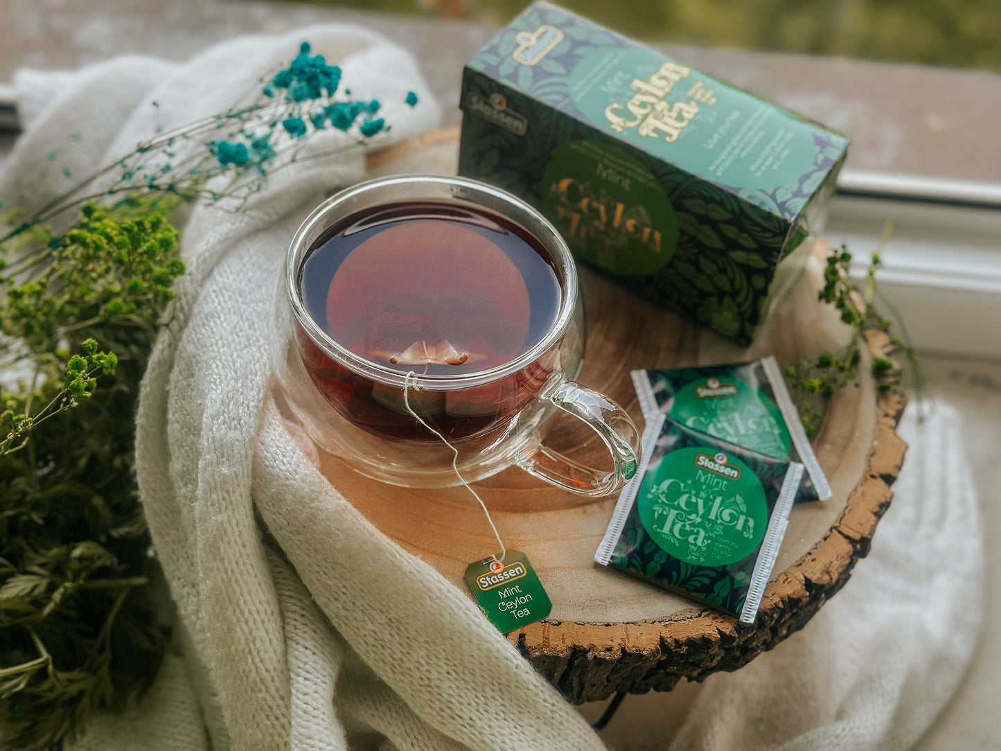 Filiżanka z naparem i opakowaniem Stassen Mint Black Tea w tle.