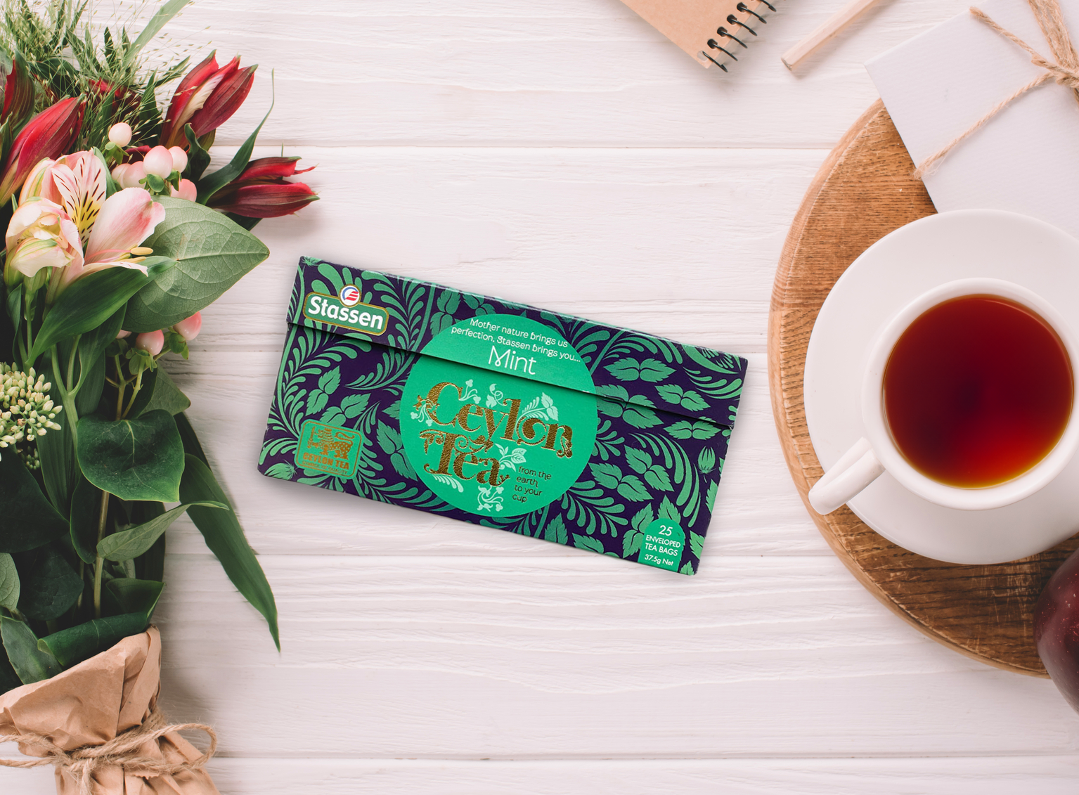 Herbata Stassen Mint Black Tea zaprezentowana z bukietem kwiatów.