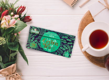 Herbata Stassen Mint Black Tea zaprezentowana z bukietem kwiatów.