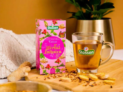 Pudełko herbaty ziołowej Stassen Detox z filiżanką naparu na drewnianej desce