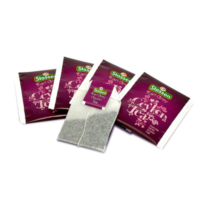 Saszetki i torebka herbaty Stassen Earl Grey na tle białym, gotowe do zaparzenia.