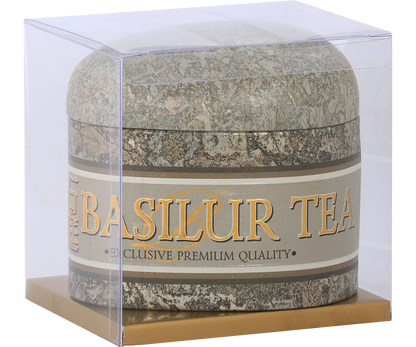 Puszka herbaty Basilur Oolong Green Tea w kamiennym stylu w przezroczystym opakowaniu.