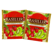 Dwie saszetki herbaty Basilur Strawberry & Kiwi w złotym opakowaniu.