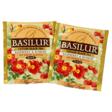 Dwie saszetki herbaty Basilur Raspberry & Rosehip w złotym opakowaniu.