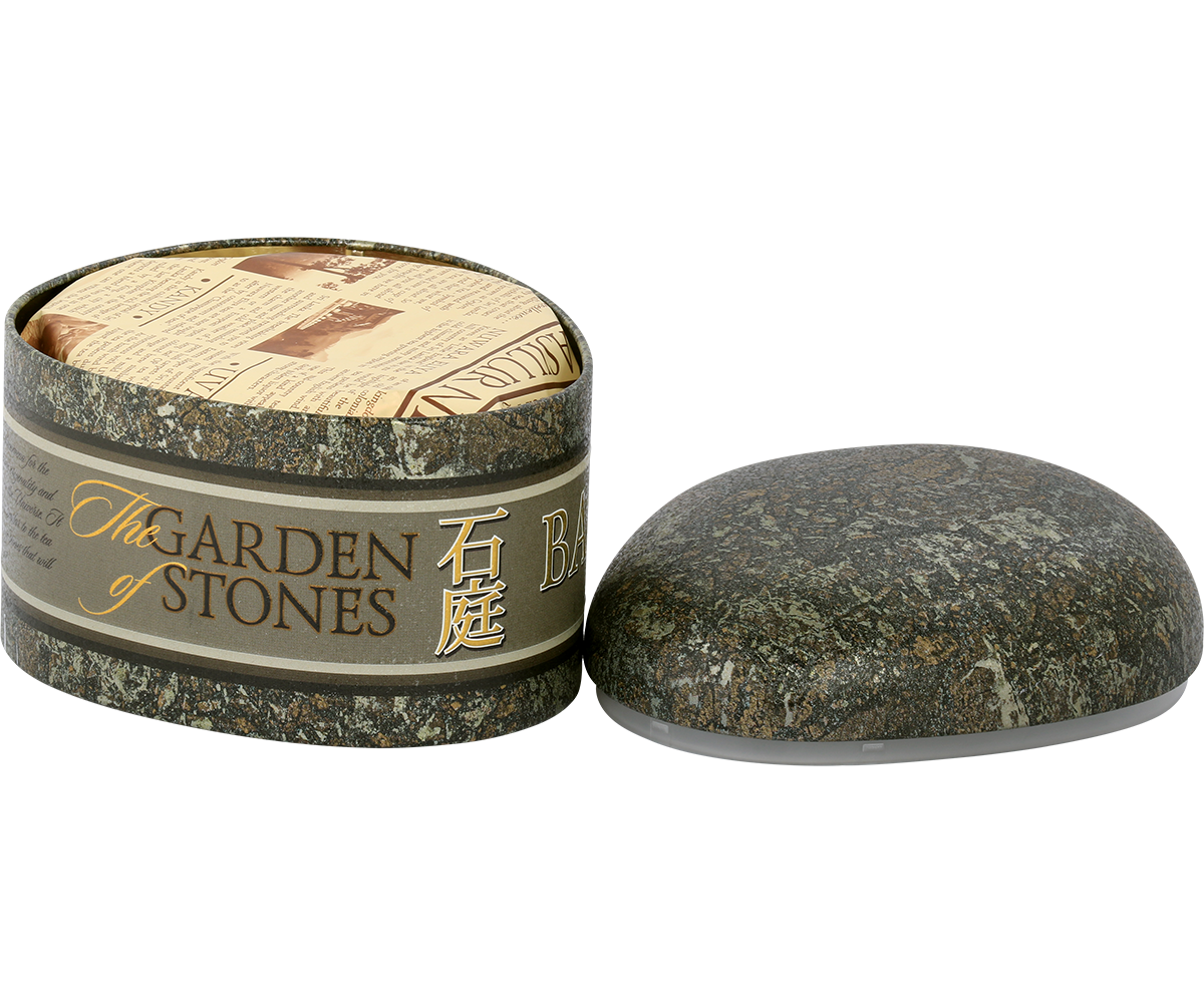 Otwarta puszka Basilur Ceylon z eleganckim papierowym zabezpieczeniem herbaty.