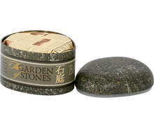 Otwarta puszka Basilur Ceylon z eleganckim papierowym zabezpieczeniem herbaty.