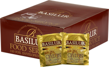 Opakowanie herbaty Basilur Gold z widocznymi saszetkami czarnej herbaty cejlońskiej w złotych kopertach.