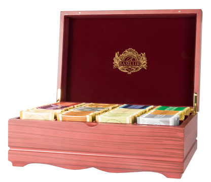 Otwarte drewniane pudełko Basilur z herbatami w saszetkach prezentujące kolekcję dwunastu smaków.
