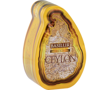 Herbata Basilur Gold w ozdobnym, metalowym opakowaniu widziana z lewej strony.