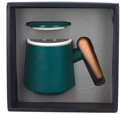 Zielony kubek ceramiczny z drewnianym uchem, sitkiem i przykrywką w zestawie prezentowym.