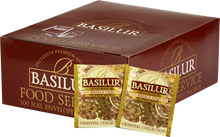 Opakowanie herbaty Basilur Masala Chai z widocznymi saszetkami czarnej herbaty cejlońskiej z przyprawami w złoto-brązowych kopertach z orientalnym wzorem.