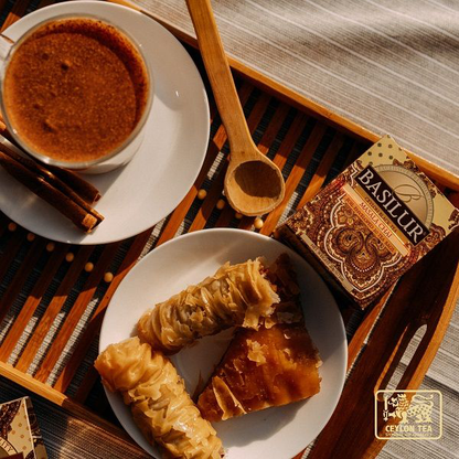 Zestaw z herbatą Basilur Masala Chai, deserem i filiżanką naparu.