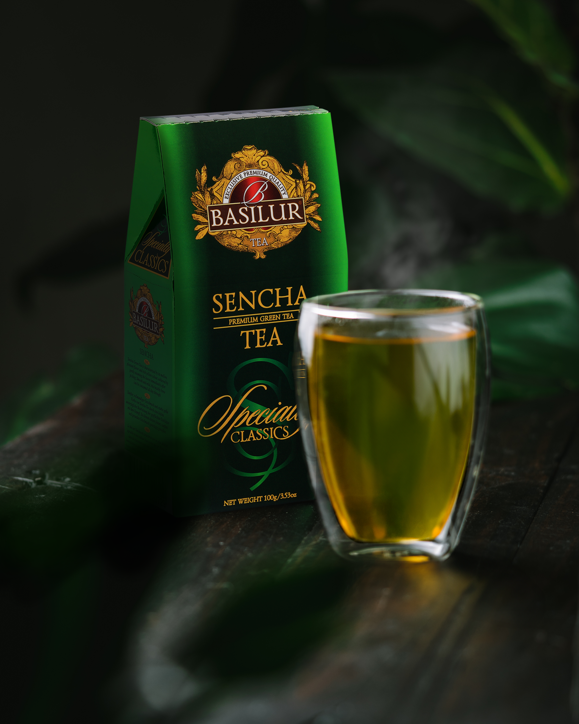 Szklanka naparu zielonej herbaty Basilur Sencha obok pudełka.