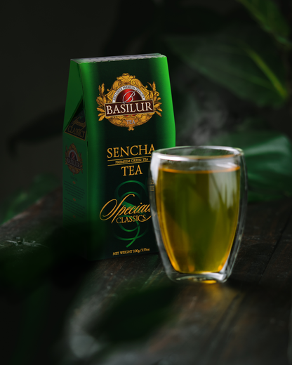 Szklanka naparu zielonej herbaty Basilur Sencha obok pudełka.