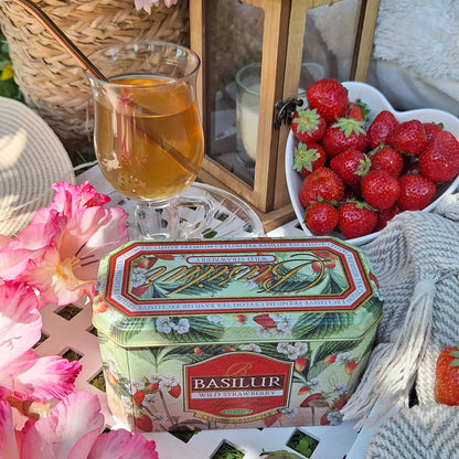 Herbata Basilur Wild Strawberry z truskawkami, naparem i kwiatami w letniej aranżacji