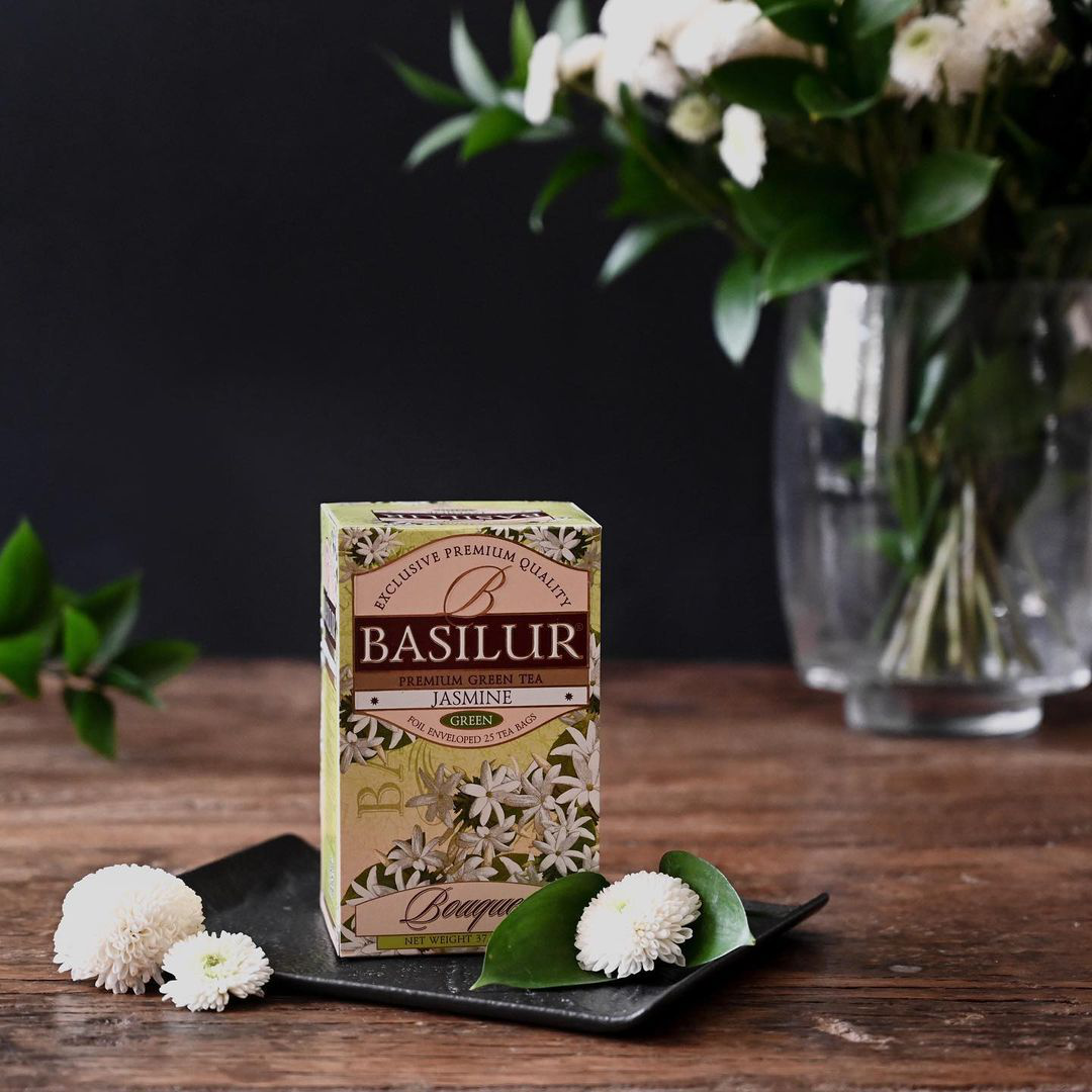 Zielona herbata Basilur Jasmine na tle kwiatów jaśminu.

