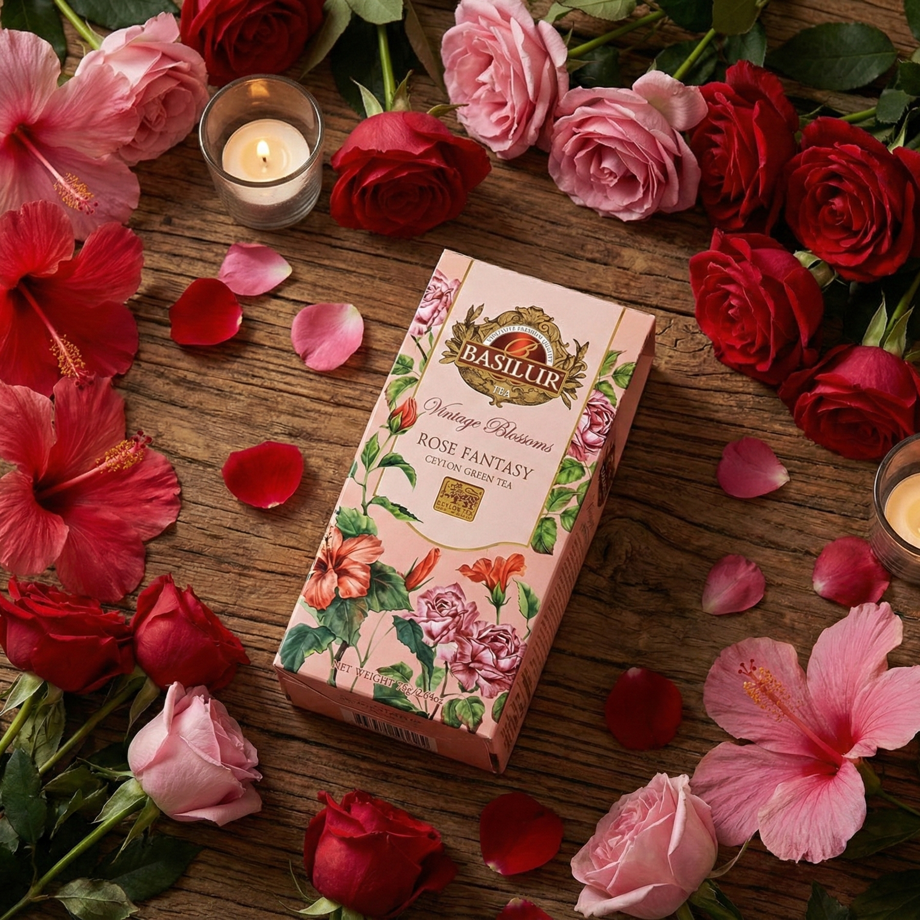 Herbata Basilur Rose Fantasy na drewnianym stole, otoczona czerwonymi i różowymi różami, płatkami kwiatów i zapalonymi świecami, romantyczny klimat.