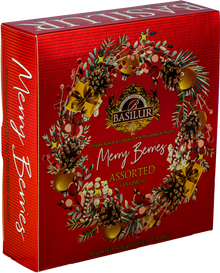 Zestaw herbat Basilur Merry Berries vol. II w czerwonym opakowaniu z zimowym wieńcem i złotymi ozdobami.