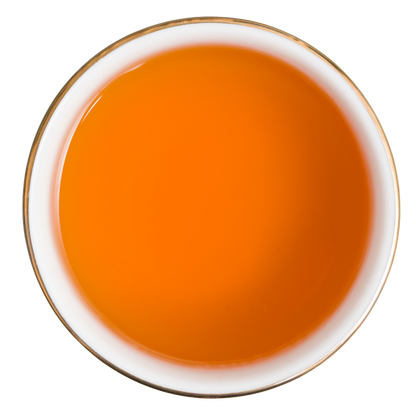Bursztynowo-pomarańczowy napar czarnej herbaty Basilur Orange and Orange Blossom widziany z góry.