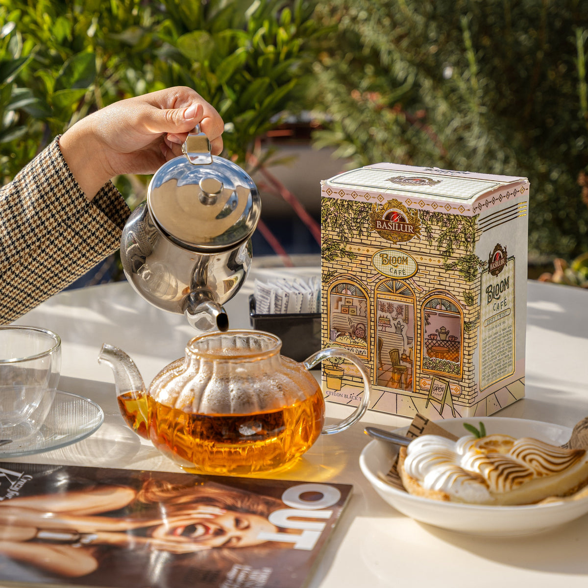 Herbata Basilur Bloom Cafe Zesty Twist na stoliku obok szklanego dzbanka z naparem i deseru