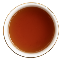Napar z herbaty czarnej Basilur Tea Candle Red o bursztynowej barwie w filiżance.