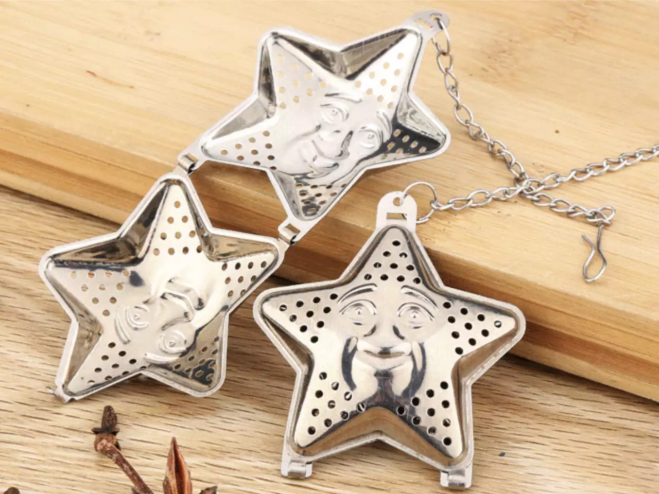 Zaparzacz do herbaty w kształcie gwiazdki na łańcuszku Carmani na drewnianej desce