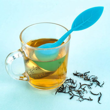 Zaparzacz do herbaty w kształcie jajka z niebieskim silikonowym listkiem w kubku