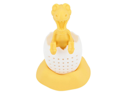 Zaparzacz do herbaty Żółty Dinozaur siedzący w jajku na silikonowej podstawce.