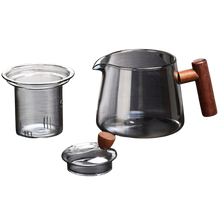 Czajnik szklany z wyjmowanym zaparzaczem i pokrywką obok.