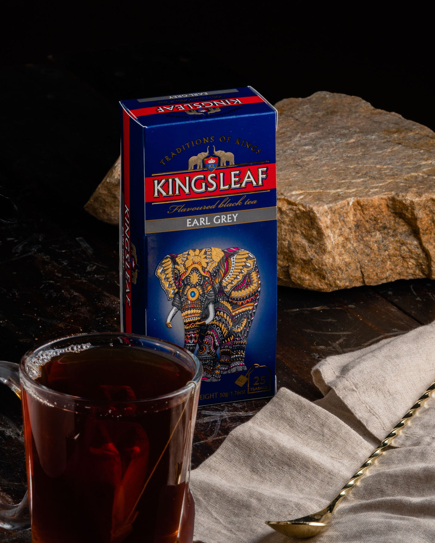 Pudełko herbaty Kingsleaf Earl Grey obok filiżanki z ciemnym naparem i łyżeczką.