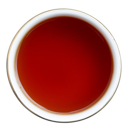 Filiżanka czarnej herbaty Earl Grey o intensywnej bursztynowoczerwonej barwie, widok z góry.