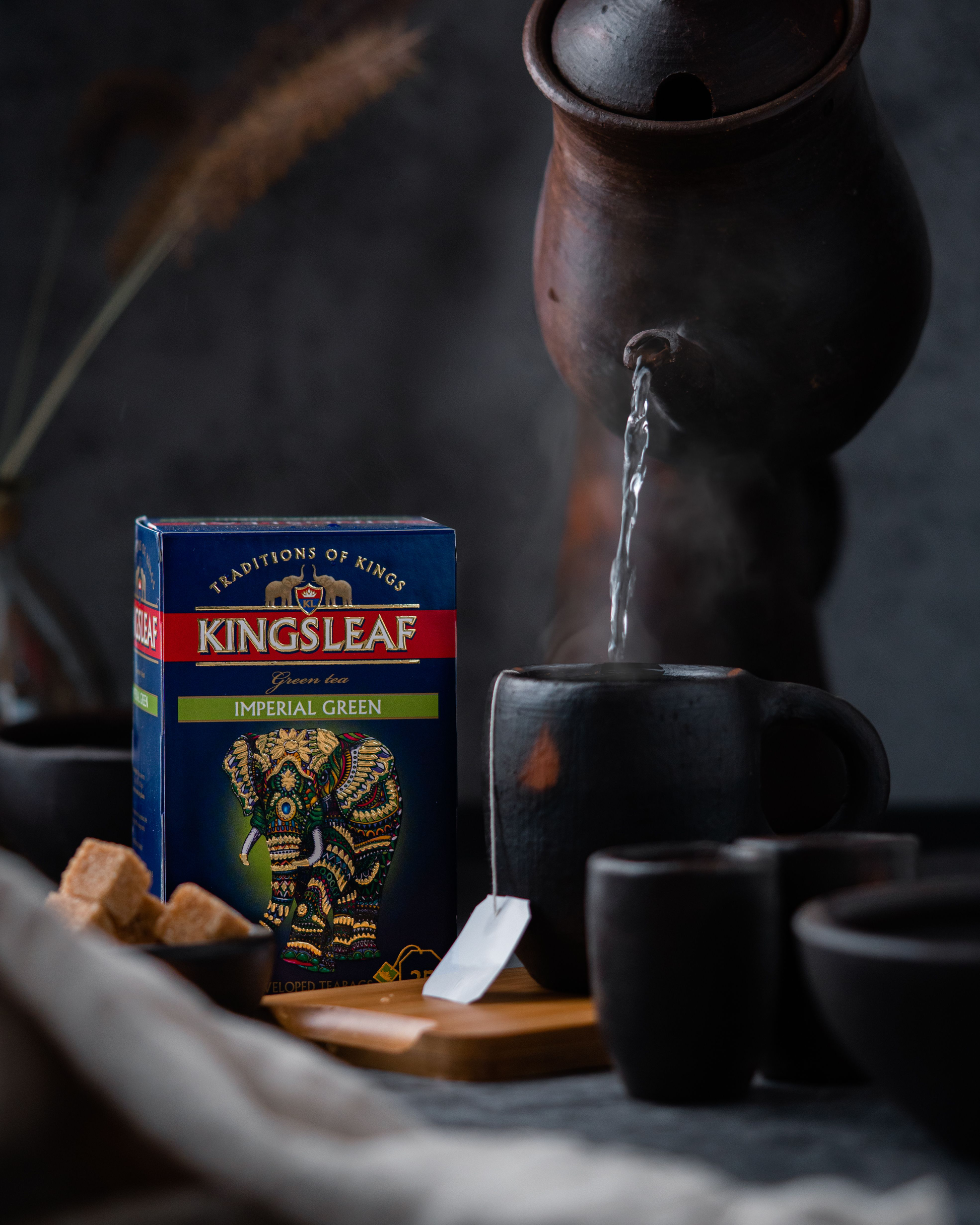 Opakowanie Kingsleaf Imperial Green przy filiżance z parzoną herbatą – aromatyczna zielona herbata premium.