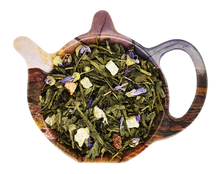 Zielona herbata Sencha Rafaella z ananasem, truskawką, porzeczką i płatkami malwy w naczyniu w kształcie czajniczka.