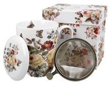 Zestaw: kubek porcelanowy Zahra 380 ml, pokrywka i zaparzacz, zaprezentowany obok ozdobnego pudełka.