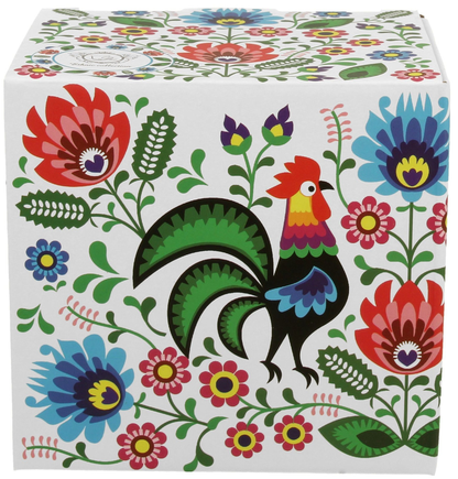 Pudełko prezentowe z kolorowym motywem folkowym i kogutem, w którym zapakowany jest kubek porcelanowy.
