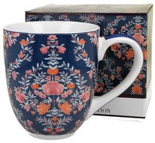 Kubek porcelanowy Manu Blue ustawiony obok ozdobnego pudełka, prezentujący bogaty kwiatowy wzór.