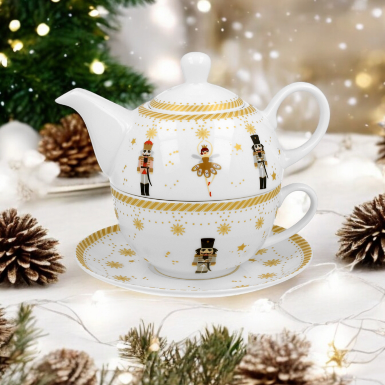 Filiżanka, dzbanek i spodek Christmas Balerina ustawione przy udekorowanej choince.